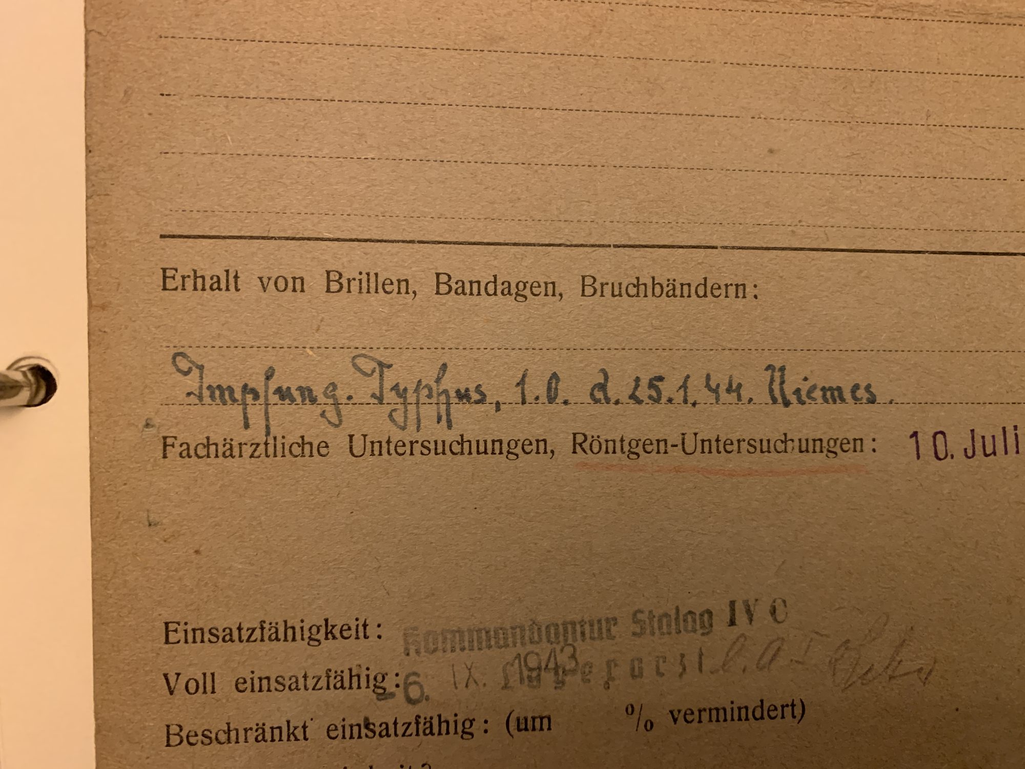 Detail van de voorzijde van de Gesundheitskarte, met de tyfusvaccinatie in Niemes en de 'voll einsatzfähig'-stempel.
